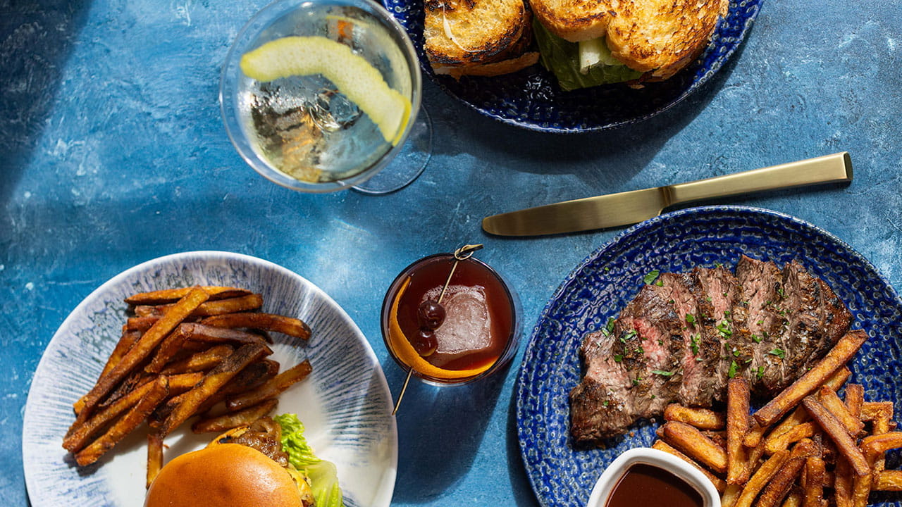 Spread of modern dishes at OLINDA – artisan sandwich, steak frites, burger and fries, and signature cocktails at Gervasi Vineyard